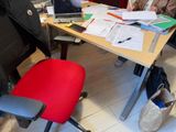 several people sitting at a table with laptops and papers on it