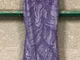une robe violette suspendue à un cintre accroché au mur