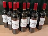 six bouteilles de vin rouge sont alignées sur une table