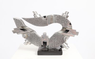 a metal sculpture of a heart on a white surface
