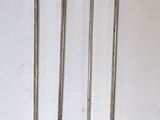 quatre ciseaux en métal sont alignés contre un mur blanc