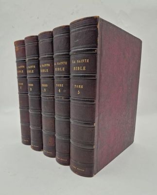 trois vieux livres sont alignés sur une surface blanche