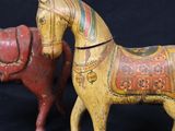 these are two small wooden horses with a red and yellow one