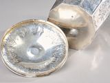 a silver container with a lid on a white surface