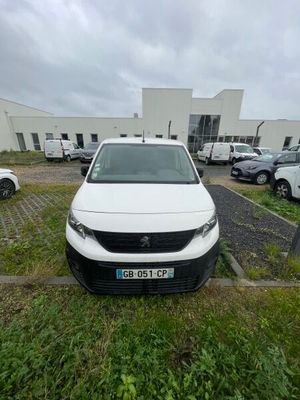 la camionnette blanche est garée dans un parking avec d'autres voitures