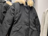 two coats hanging on a rack in a clothing store