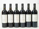 six bouteilles de vin sont alignées sur une surface blanche