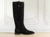 a pair of black boots sitting on top of a wooden floor