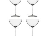quatre verres à vin vides empilés les uns sur les autres sur une surface blanche