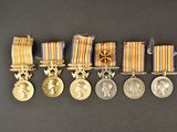 five medals and a medal on a black surface