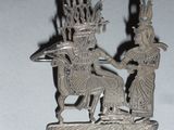a silver statue of a man and a woman on a horse