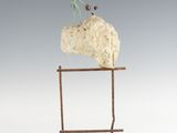 statue of a man riding a horse on a rock on a wooden stand