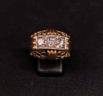 gros plan d'une bague en or et diamants sur une surface noire