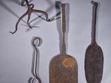 trois vieux outils posés sur une surface blanche