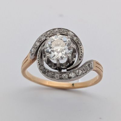 un gros plan d'une bague en diamant et en or sur fond blanc