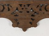 an old wooden shelf with a clock on top of it
