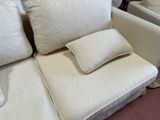 two white couches with pillows on them in a room