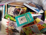 une pile de livres pour enfants posée sur un lit