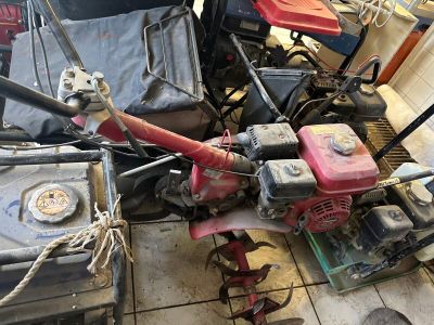 plusieurs tondeuses à gazon posées sur un sol carrelé