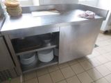 un plan de travail en acier inoxydable sur lequel sont posées des assiettes, dans une cuisine