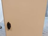 un réfrigérateur blanc avec un bouton noir sur la porte