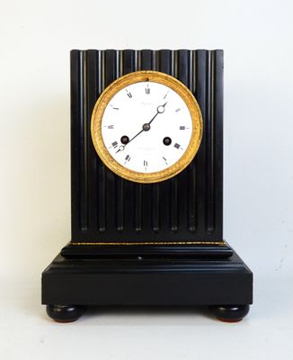 a black and gold clock sitting on top of a table