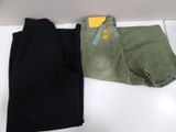 two pairs of black and green pants sitting on top of a white counter