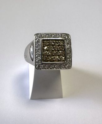 bague en argent sertie de diamants bruns et blancs sur un fond blanc