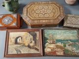 several pieces of art are sitting on a table next to a potted plant