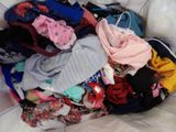 a pile of clothes sitting in a basket on a bed