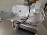an image of a commercial meat slicer on a table