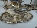 a silver plate with a bowl on top of it on a table