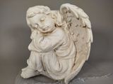 a statue of an angel sitting on top of a rock