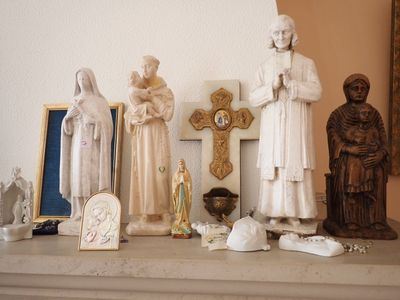 de nombreuses statues représentant des personnes debout sur une étagère à côté d'un miroir