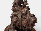 a close up of a sculpture of a plant on a wooden base