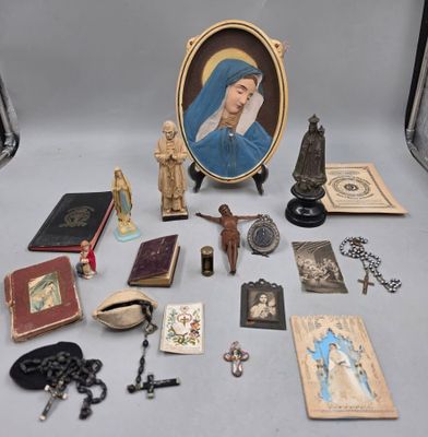 de nombreux objets religieux posés sur une table, à côté d'une photo d'une femme