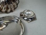a silver tray and a silver candle holder on a table