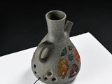 a small vase with a hole in it on a table