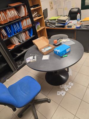 une table avec une chaise bleue et une bibliothèque en arrière-plan