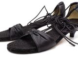 une paire de chaussures noires à lacets posée sur une surface blanche