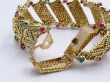 a close up of a gold bracelet on a white surface