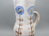 un vase blanc orné de fleurs bleues sur fond gris