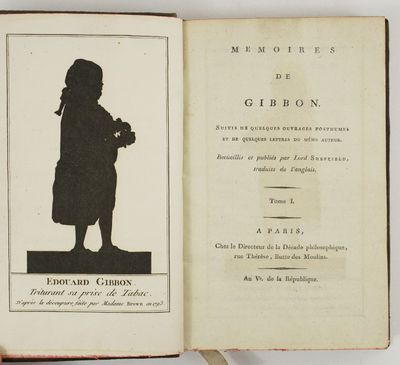 un livre ouvert sur lequel se détache la silhouette d'une personne tenant un appareil photo