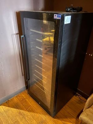 a wine cooler sitting in the corner of a room