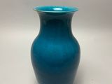 a blue vase that is sitting on a table