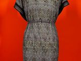 an image of a dress on a mannequin stand against a red wall