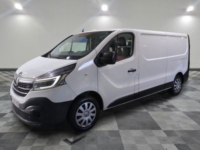 la camionnette blanche est garée sur un sol carrelé en damier