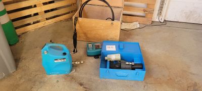 une boîte bleue équipée d'une pompe et un récipient bleu muni d'un tuyau