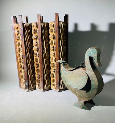 une statue représentant un oiseau à côté d'une bibliothèque
