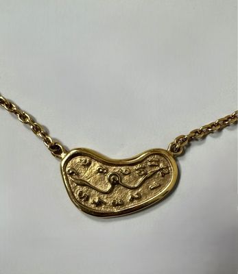 a gold plated necklace with a fish on it